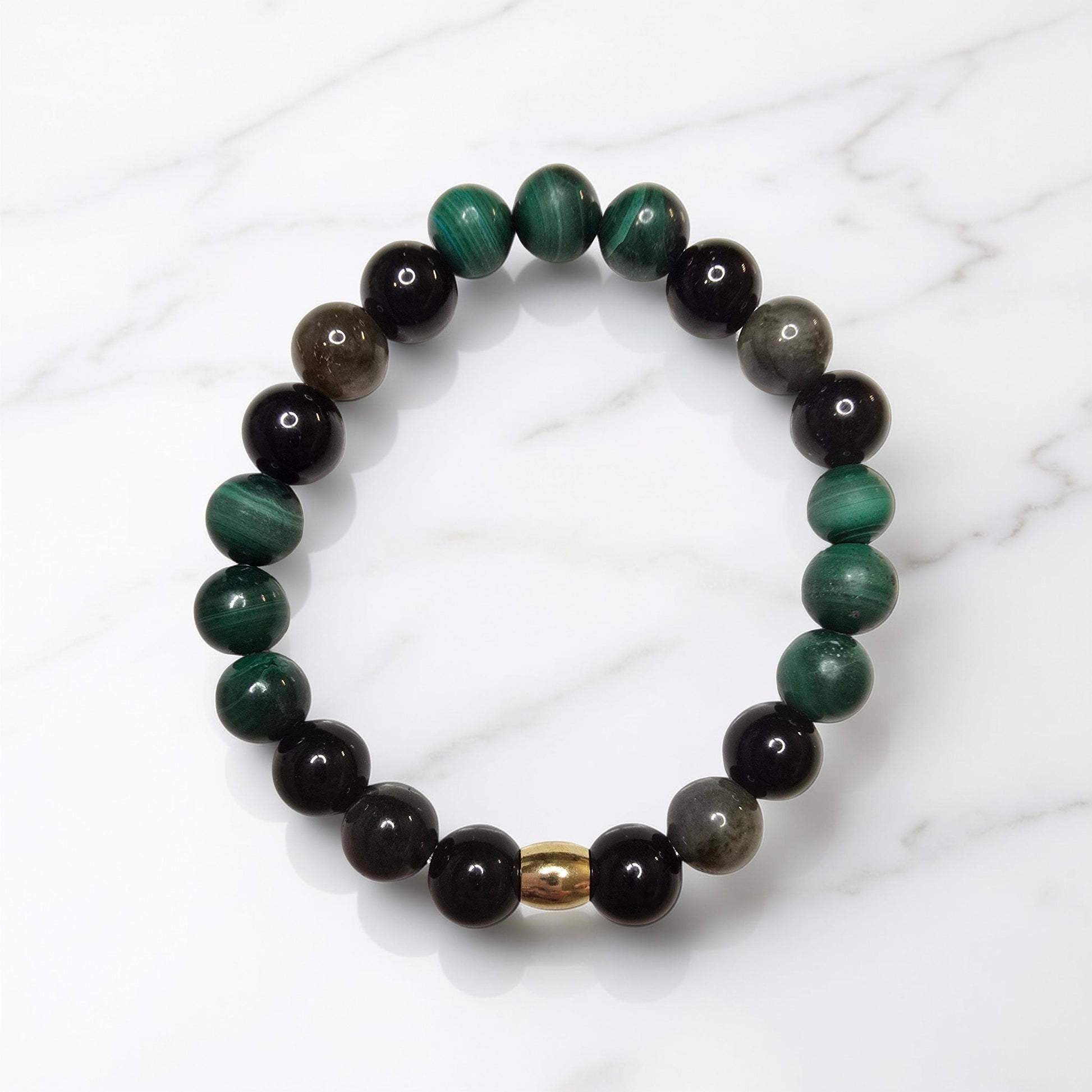 "Bracelet lithothérapie anti-douleur composé de perles de malachite verte, obsidienne dorée et tourmaline noire sur fond neutre"