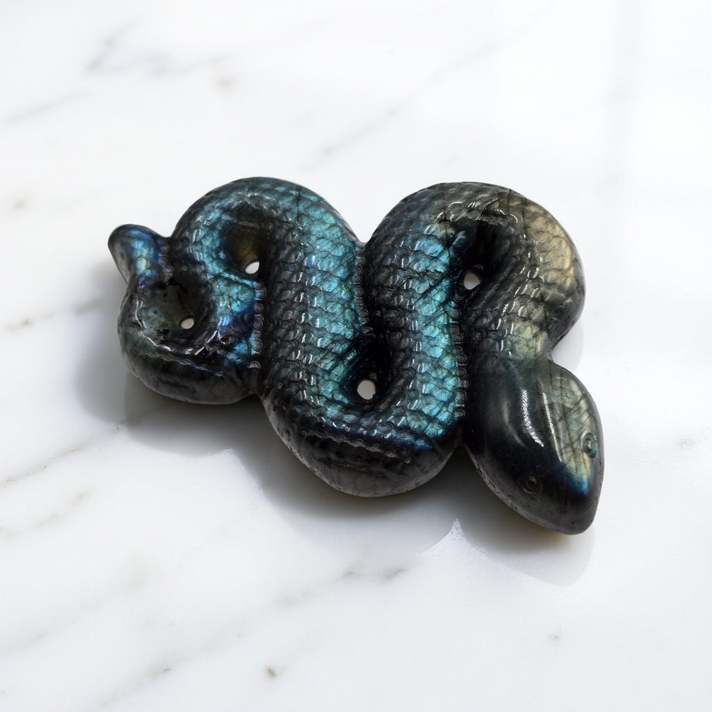 Serpent sculpté 60mm en Labradorite. Transformation, kundalini, protection énergétique. Reflets magiques chatoyants. Pièce unique.